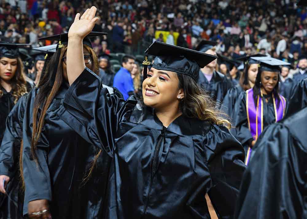 graduate smiling and waving