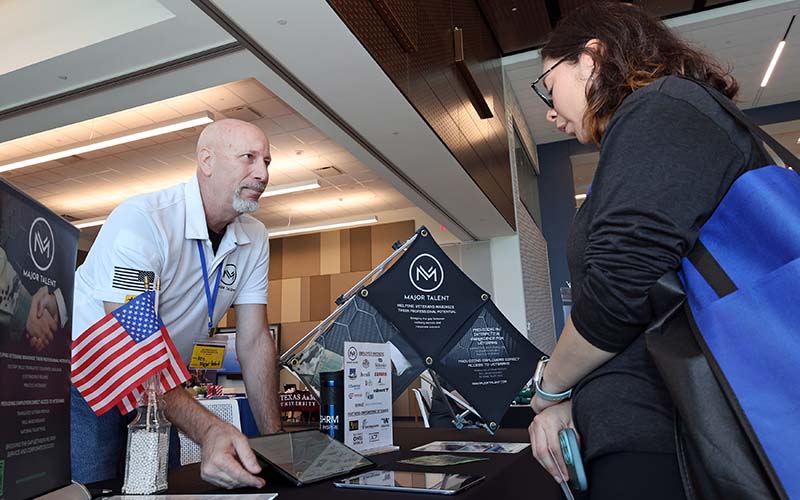Veteran talking to a vendor at San Jacinto College Veteran Resource Fair booth